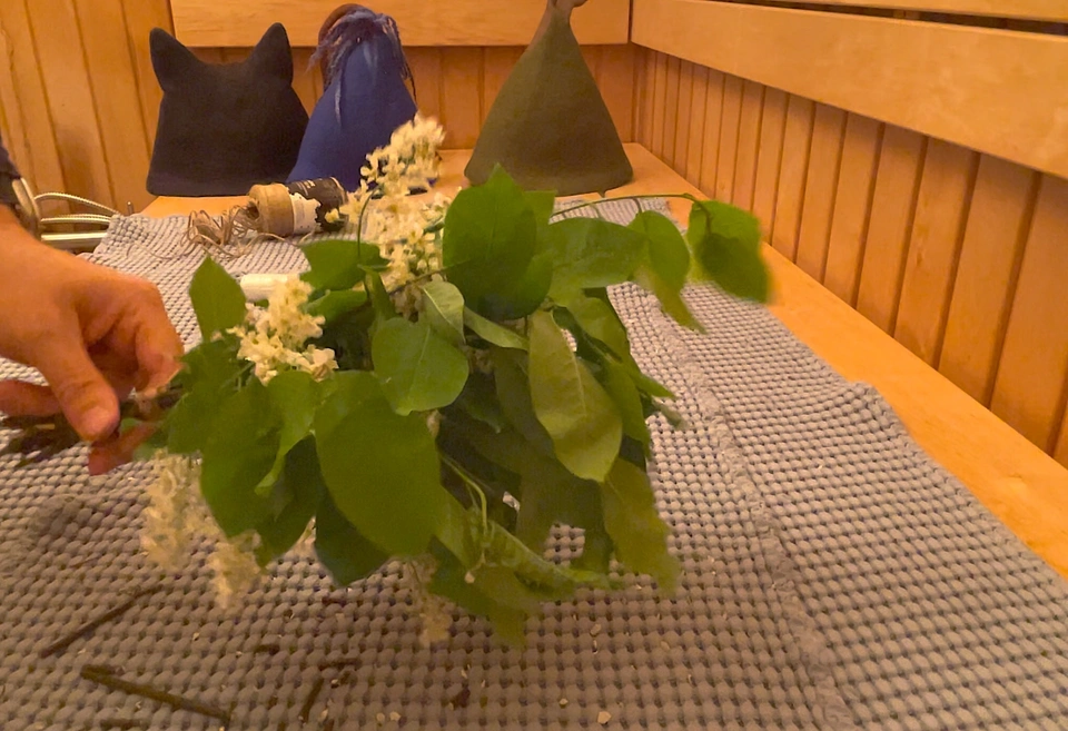 “A freshly made bird cherry sauna whisk with white blossoms, showing a tightly wrapped handle”